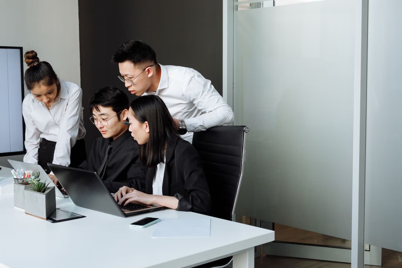Colleagues reviewing work together on a laptop